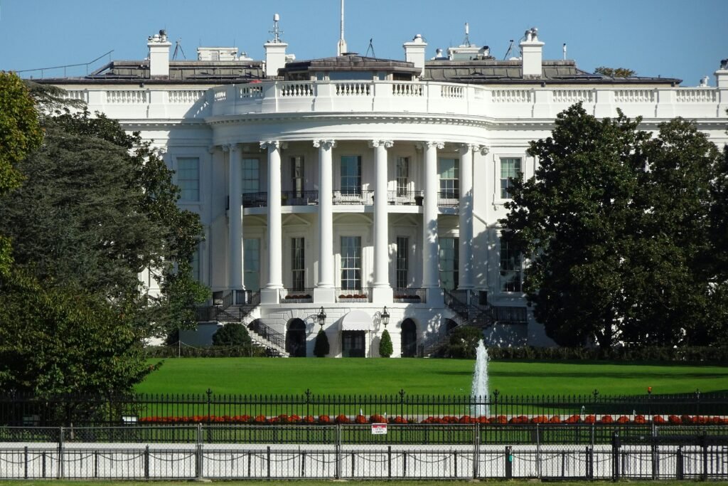 The Black Network Front view of the iconic White House in Washington, DC, showing its lawn and fountain.